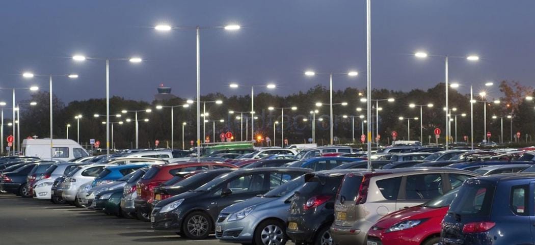 پارکینگ شبانه با نورپردازی مدرن و چند خودرو پارک‌شده