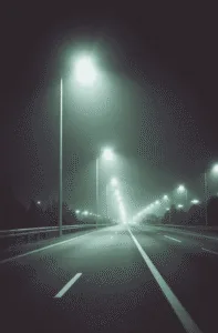 بزرگراه در شب با ردیف چراغهای خیابانی LED؛ نور سفید یکنواخت روی سطح جاده در هوای مهآلود و بدون خیرگی محسوس.
