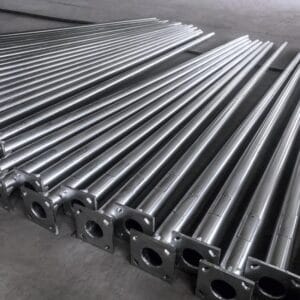 ردیفی از پایه‌های چراغ خیابانی فولادی گالوانیزهٔ گرم با بدنه مخروطی و پلیت‌های مربعی، آماده ارسال و نصب